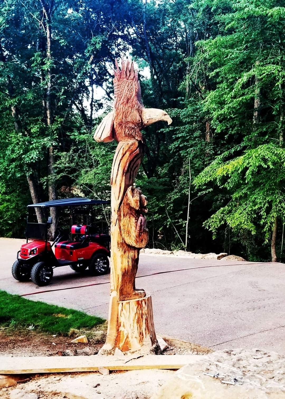 Tall standing trunk carved into an eagle perched above a leaping fish